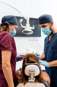 Dentist and dental assistant treating a patient