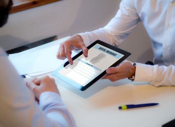 Two people looking at dental insurance information on a tablet