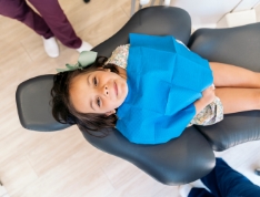 Smiling young girl sitting in dental chair