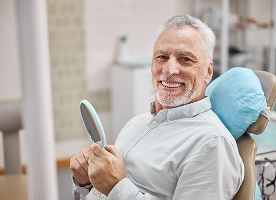 A happy elderly man sitting in a dentist’s chair