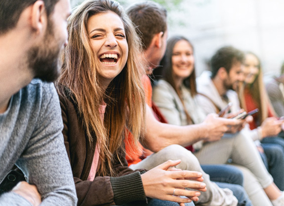 Happy CEREC crown patient smiling with friends