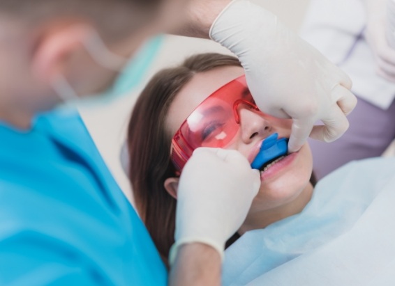 Young woman getting fluoride treatment at preventive dentistry visit