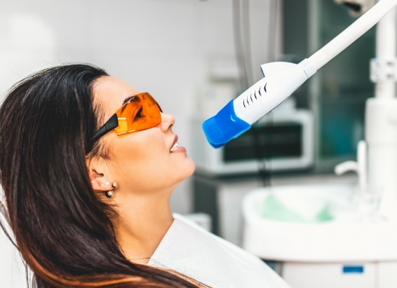 Woman getting professional teeth whitening from cosmetic dentist