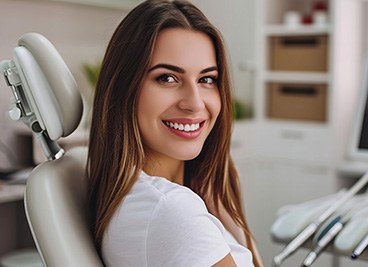 Woman smiling while sitting in dentist's treatment chair