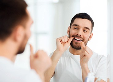 Man flossing in the bathroom