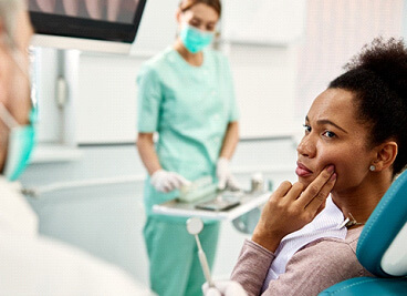 patient with toothache looking at dentist in dental office