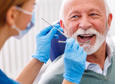 mature man smiling during dental checkup