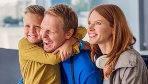 Smiling family of three sitting on couch