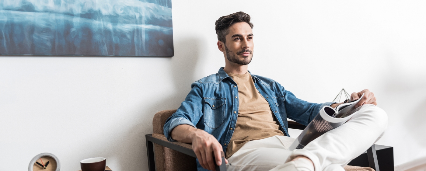Young man with short beard sitting in dental office waiting room