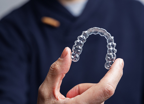 Closeup of patient holding Invisalign aligner