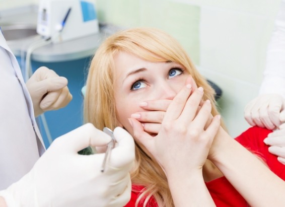 Dental patient covering her mouth in fear before sedation dentistry in York