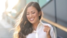 Smiling woman walking down outdoor staircase on sunny day