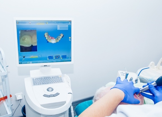 Dentist examining a patient's smile with advanced cavity detection system