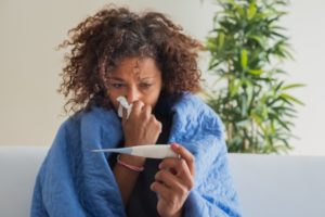 a sick woman checking her temperature