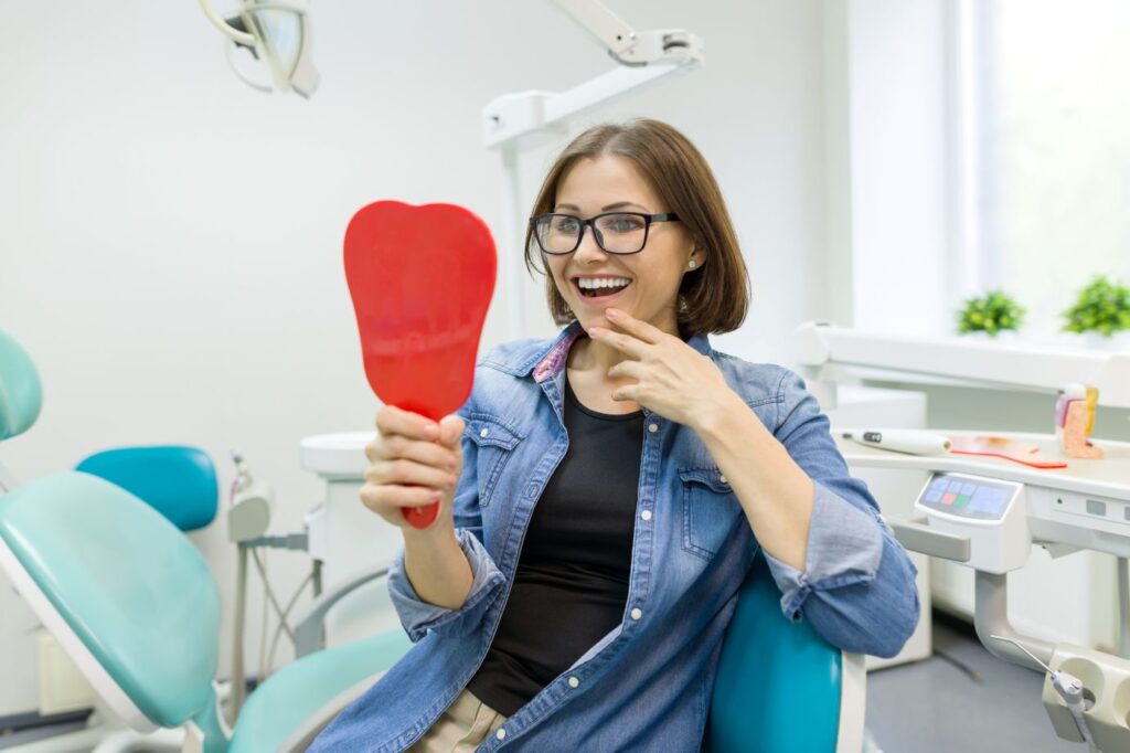 A woman looking in the mirror at her teeth